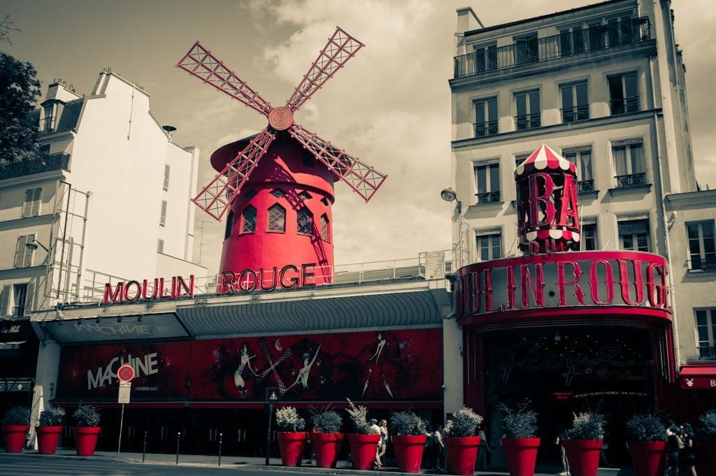 Iconic Moulin Rouge windmill and facade in Montmartre, Paris, France.